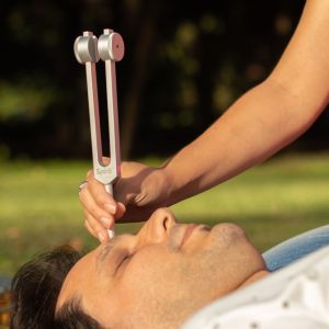 Aplicación de un diapasón durante una sesión de sonoterapia