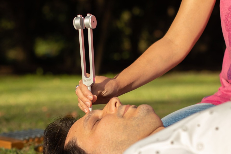 Aplicación de un diapasón durante una sesión de sonoterapia