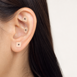Oreja con pequeñas semillas fijadas mediante parches adhesivos