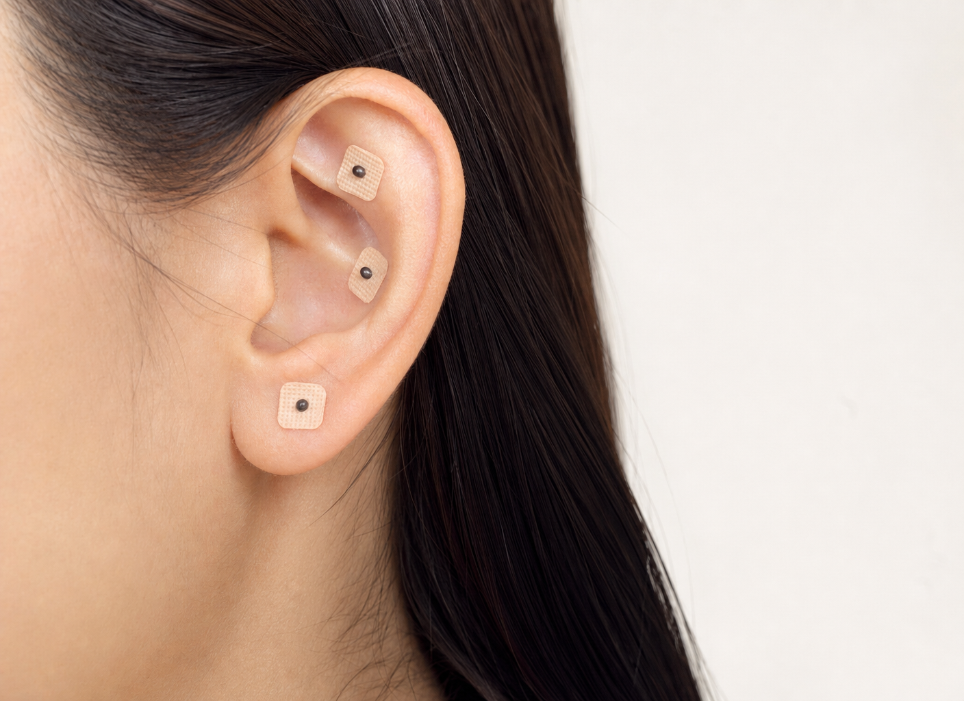 Oreja con pequeñas semillas fijadas mediante parches adhesivos